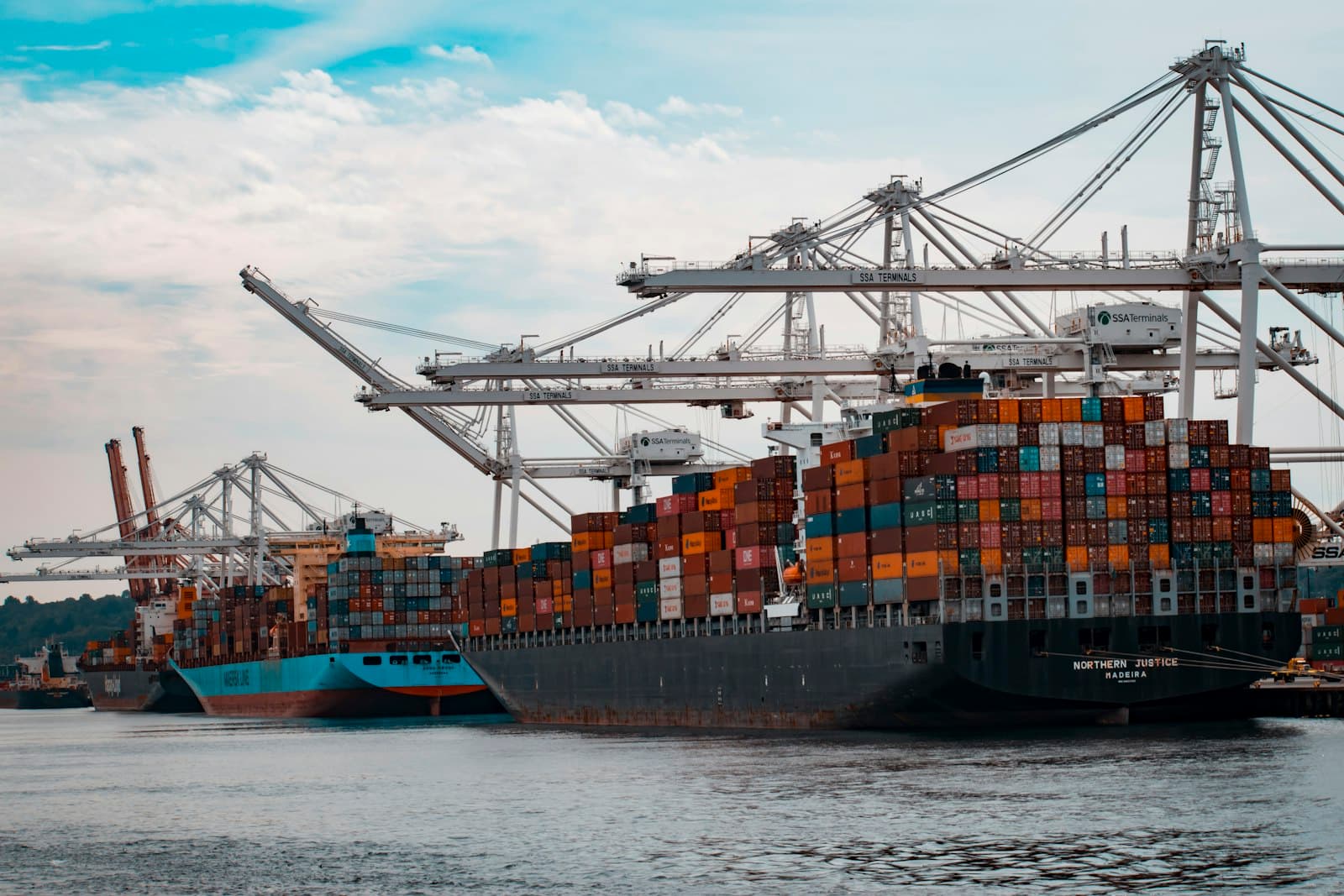 A container ship being loaded by cranes at a port